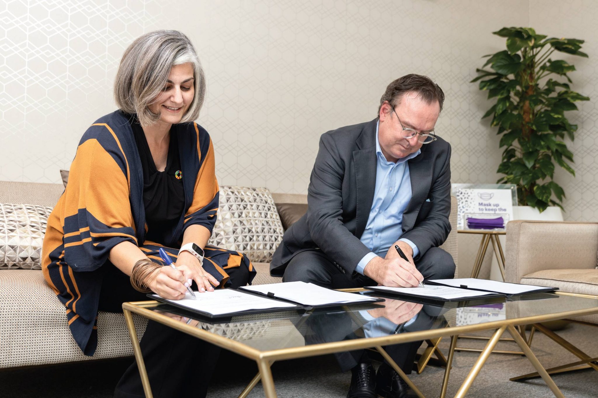 The CEO of AGF and the representative of Accenture signing papers for the Sustainable Development Goals (SDGs) 4, 8, and 17.