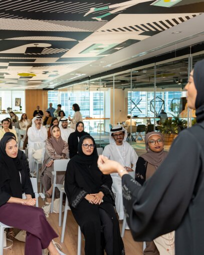 A diverse group of people attentively listening to a presenter at the Abdulla Al Ghurair Foundation in Dubai, UAE