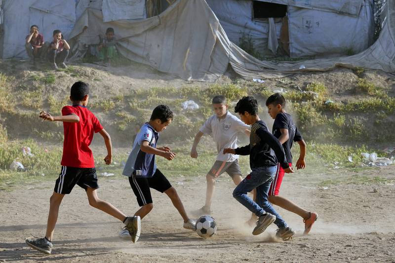 Syrian children play soccer by their tents at a refugee camp in the town of Bar Elias, in Lebanon's Bekaa Valley, Tuesday, June 13, 2023. Aid agencies are yet again struggling to draw the world's attention back to Syria in a two-day donor conference hosted by the European Union in Brussels for humanitarian aid to Syrians that begins Wednesday. Funding from the conference also goes toward providing aid to some 5.7 million Syrian refugees living in neighboring countries, particularly Turkey, Lebanon and Jordan. (AP Photo/Bilal Hussein)