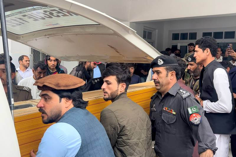 People carry a teacher's body into an ambulance from a hospital after a sectarian violence inside a school in Parachinar, Pakistan, on May 4. Five teachers and two labourers were gunned down. AFP