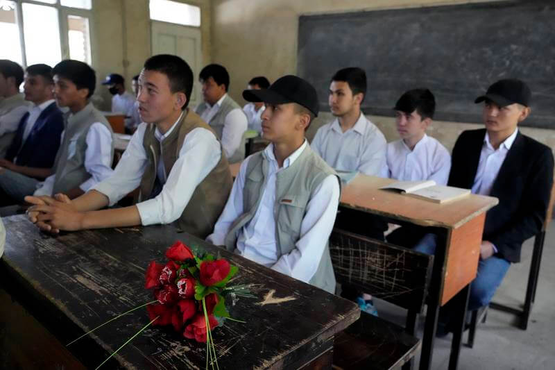 A bouquet of flowers is placed as a tribute on the desk of 19-year-old Parviz Noori who was killed in front of his school, in Kabul, Afghanistan, on April 23, 2022. AP Photo