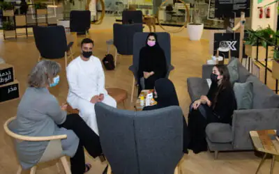 Six individuals, including officials from the AGF, are seated in a modern workspace, engaged in conversation.