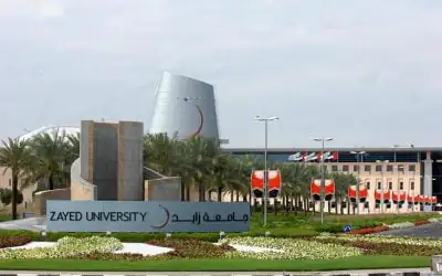 The entrance to Zayed University features a bilingual sign displaying “ZAYED UNIVERSITY” in both English and Arabic.