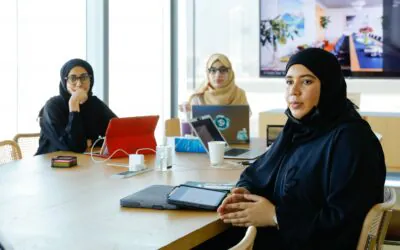 Four individuals seated around a conference table in a modern office, engaged in discussion-AGF