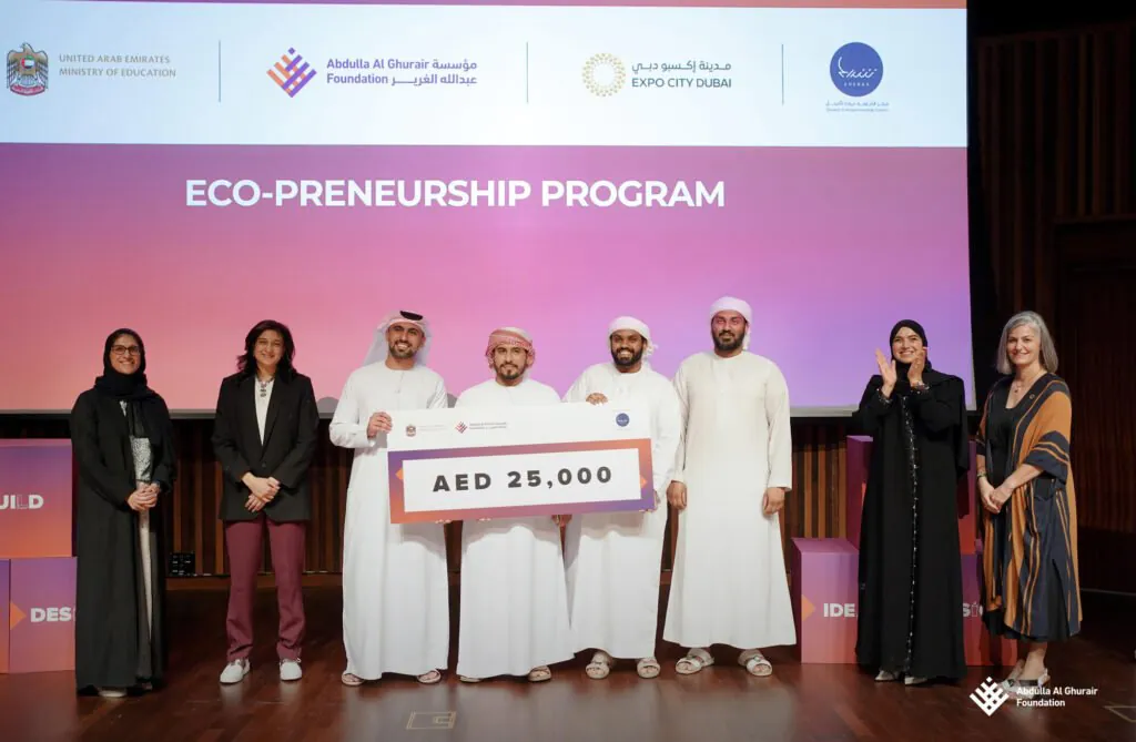 Eco-Preneurship Program event by AGF, featuring participants on stage holding a ceremonial AED 25,000 check.