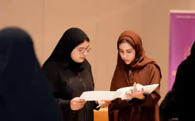 Two Arab women students, reviewing documents and discussing together